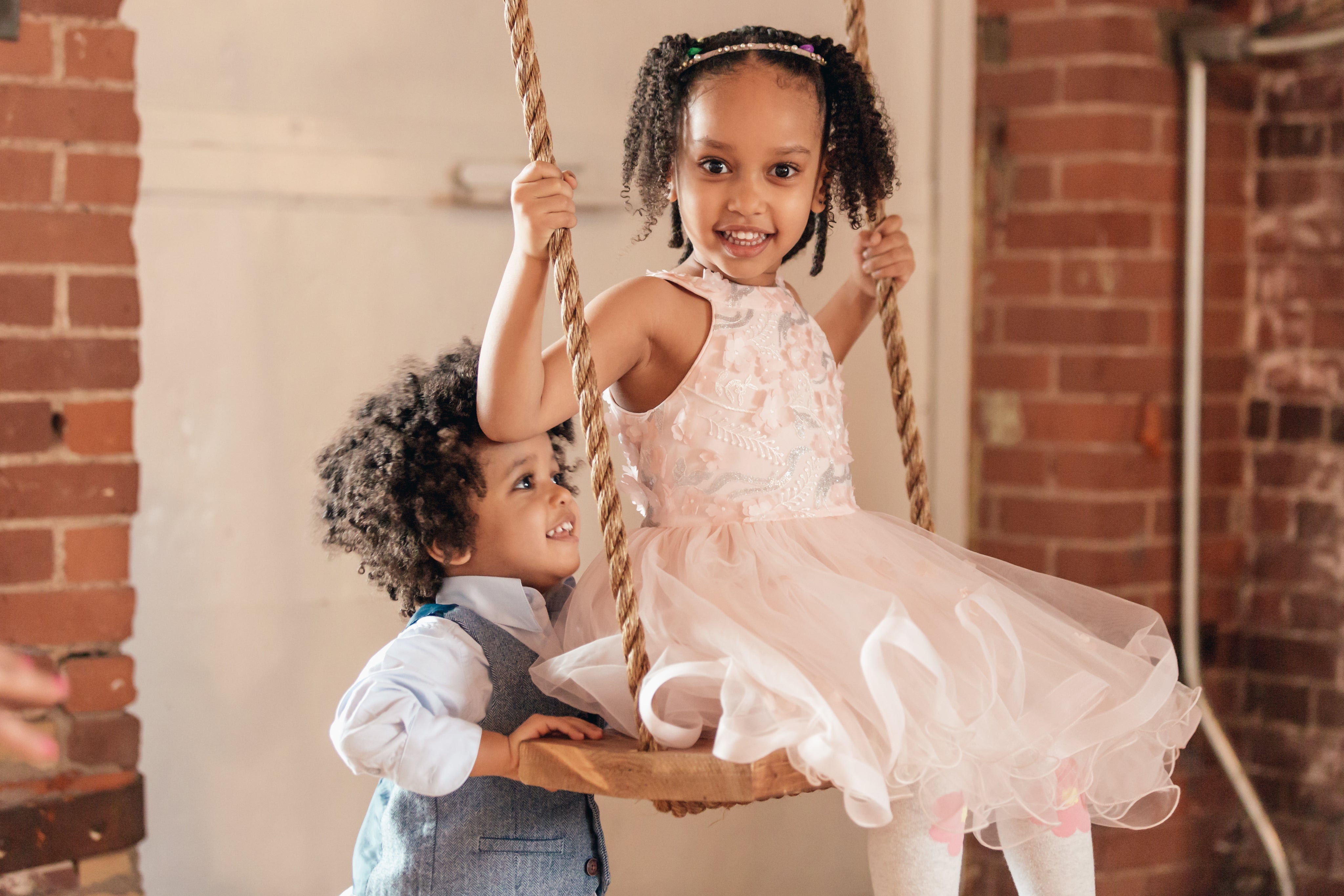 young-boy-pushes-sister-on-swing.jpg